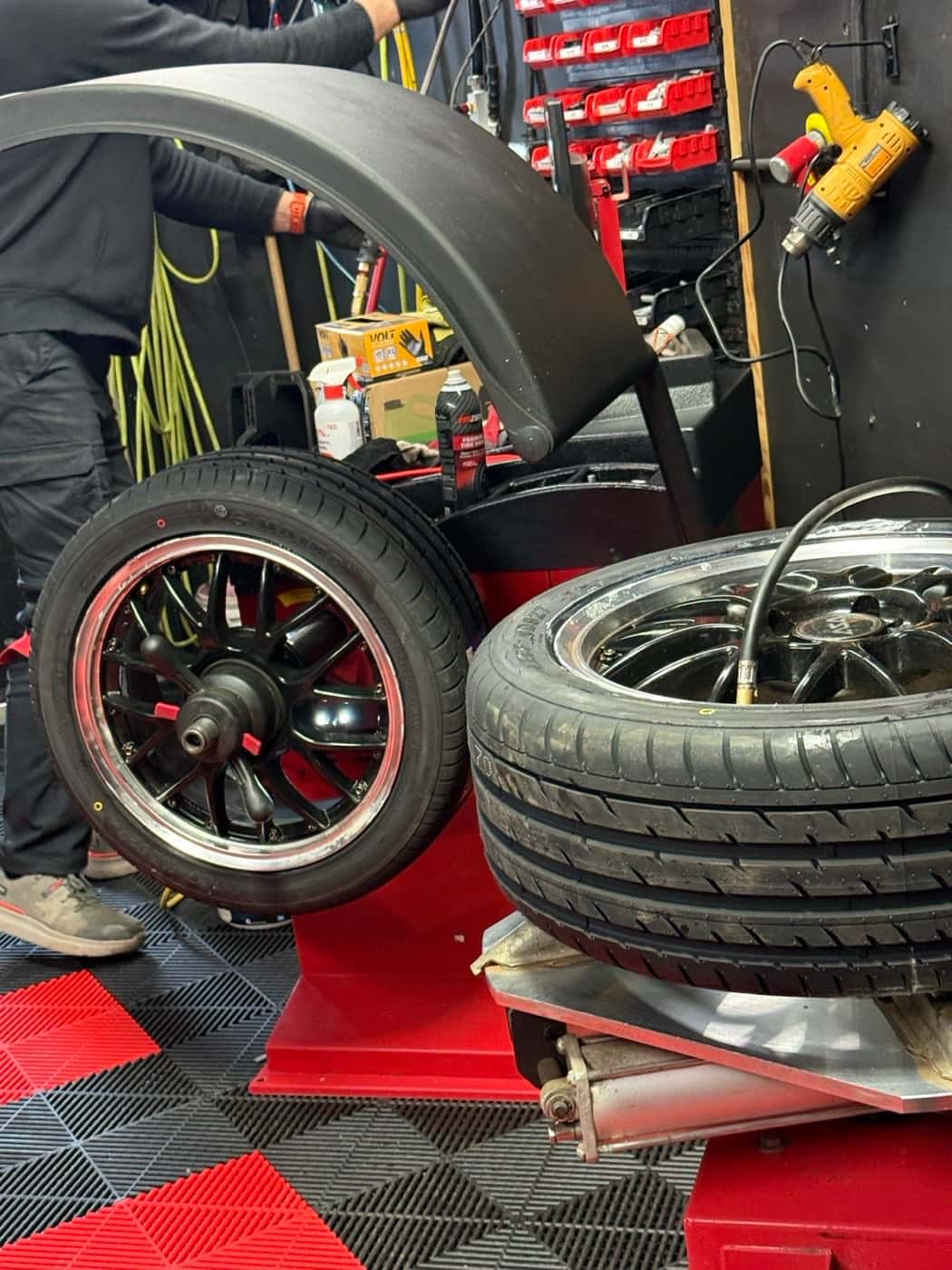 Two wheels side by side on the floor at PitStop & Go during a seasonal changeover