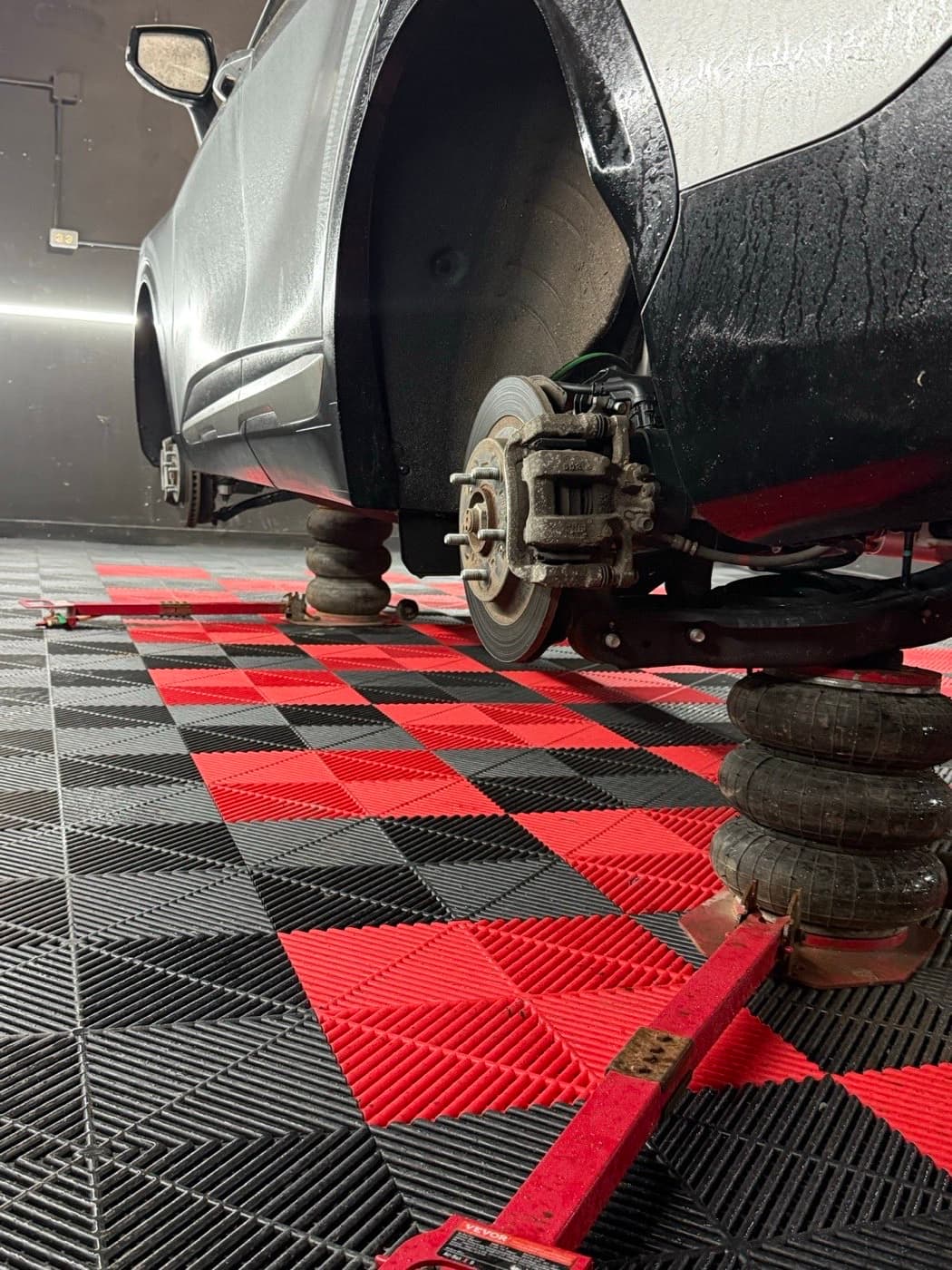 SUV raised on air jacks with all four wheels off mid-rotation