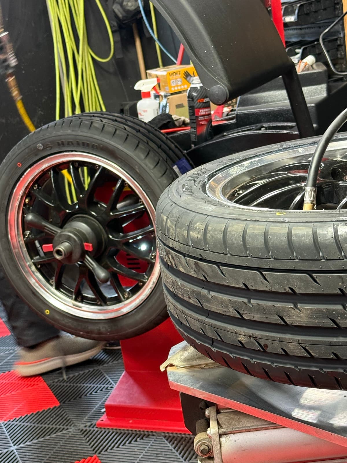 Black multi-spoke rim on the red tire-mounting machine