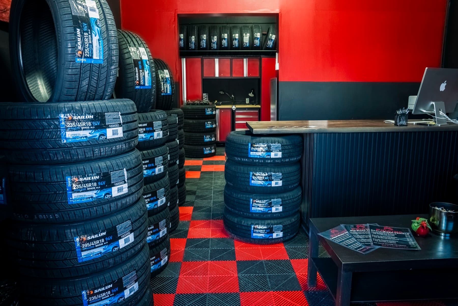 Sailun tire showroom inside PitStop & Go — stacks of tires on red and black checker floor