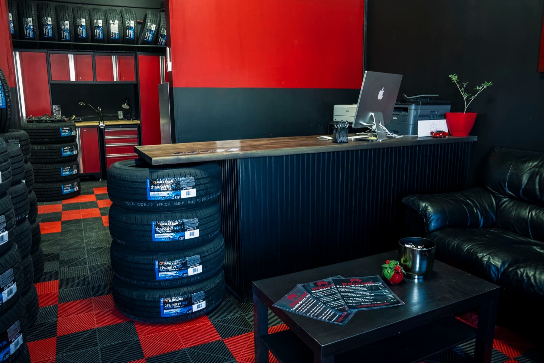 PitStop & Go waiting area, iMac counter, leather couch, tire stacks behind